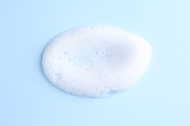 Sample of fluffy foam on light blue background, top view