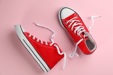 Pair of trendy sneakers on pink background, flat lay