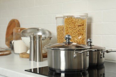 Photo of Pot and saucepan on electric stove in kitchen. Cooking utensils