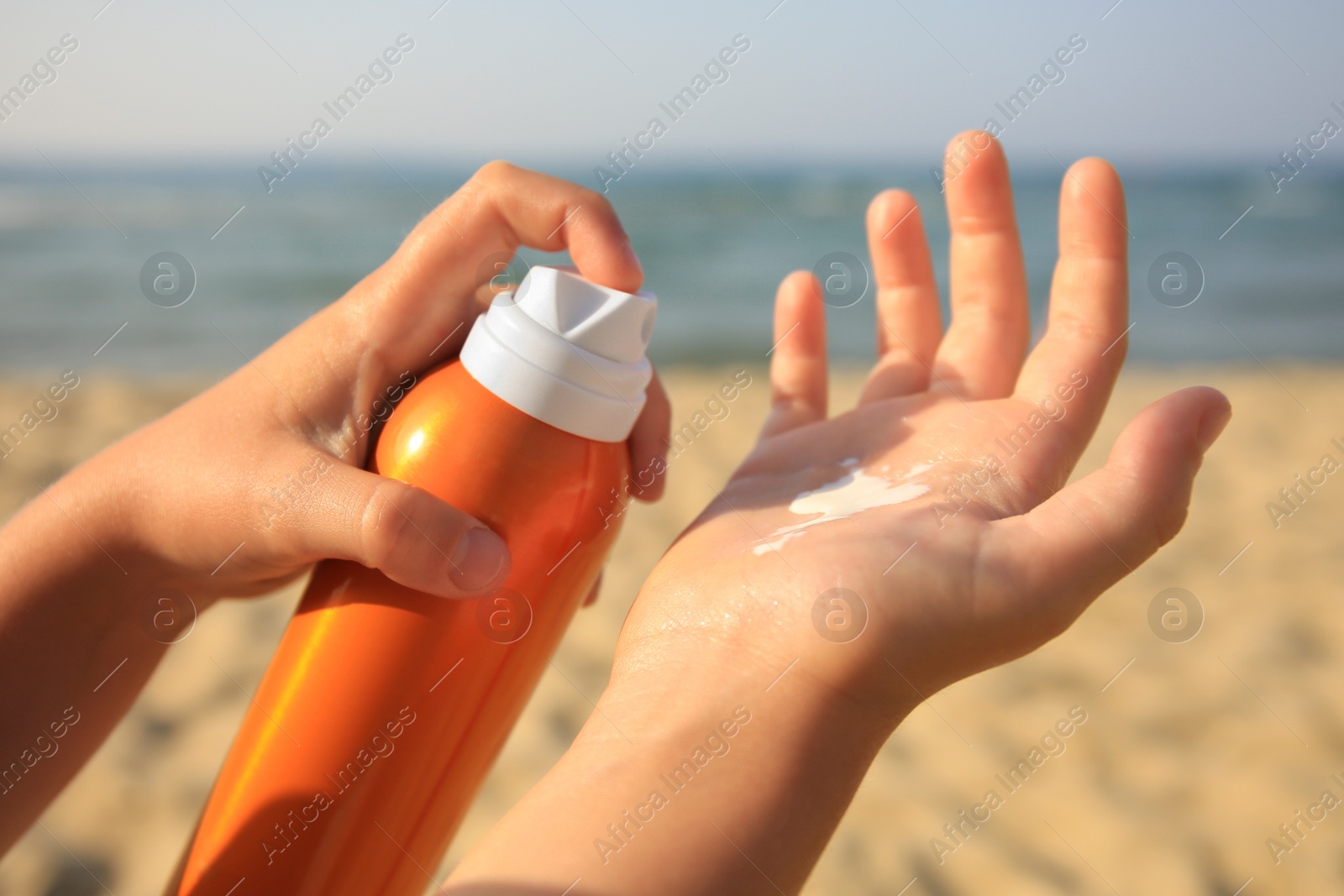 Photo of Child applying sunscreen near sea, closeup. Sun protection care