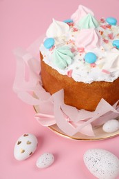 Photo of Traditional Easter cake with meringues and painted eggs on pink background, closeup