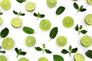 Fresh lime slices and mint leaves on white background, flat lay