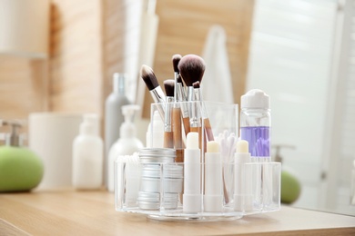 Photo of Organizer with cosmetic products on wooden table in bathroom