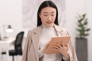 Photo of Portrait of smiling businesswoman with tablet in office