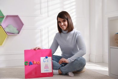 Photo of Happy female English teacher giving lesson indoors. Early childhood education