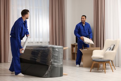 Photo of Male movers with sofa and pillow in new house