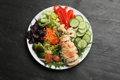 Photo of Balanced diet and healthy foods. Plate with different delicious products on black table, top view