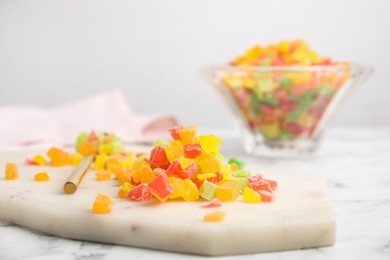 Photo of Mix of delicious candied fruits on white board, closeup