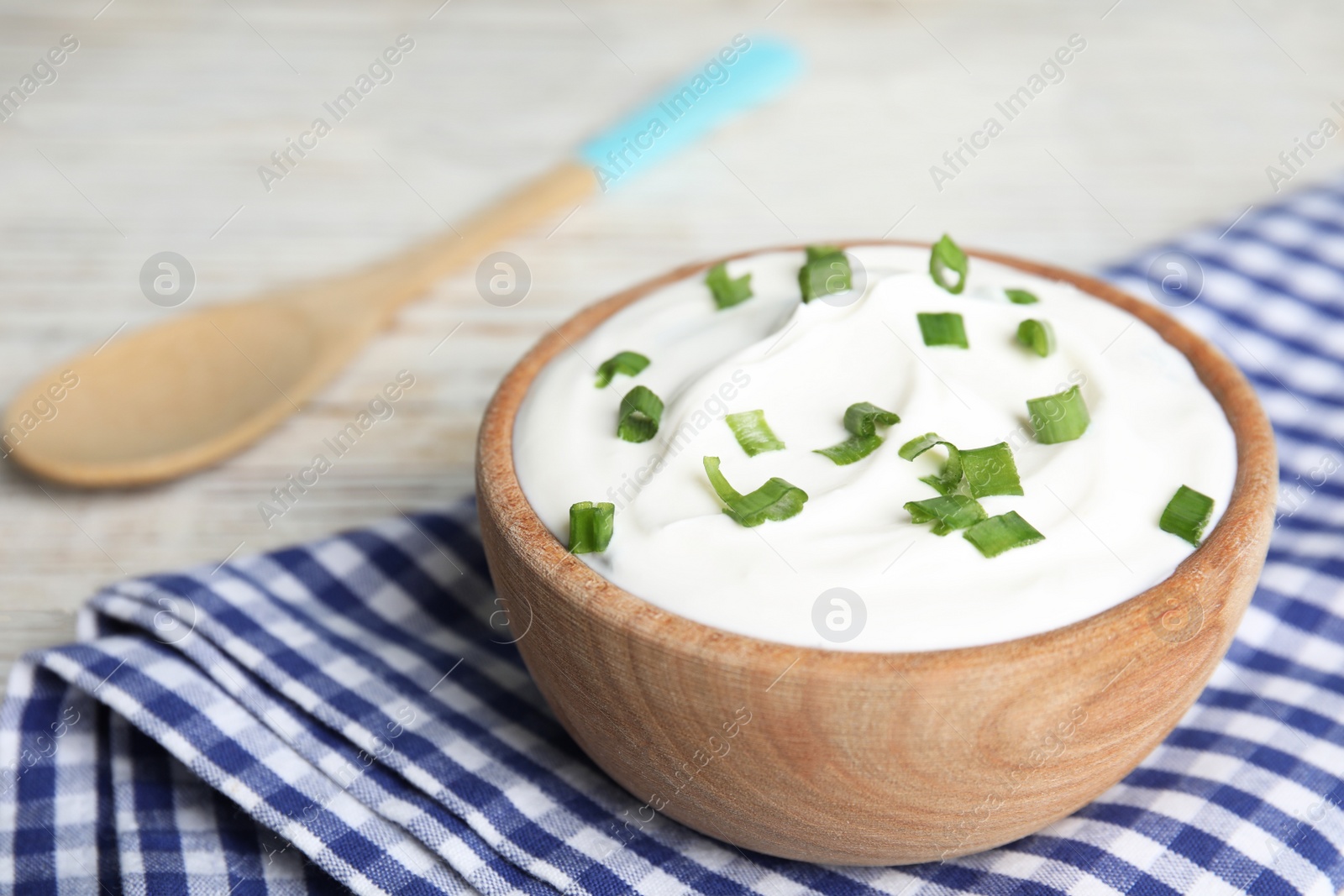 Photo of Fresh sour cream with onion on fabric, closeup