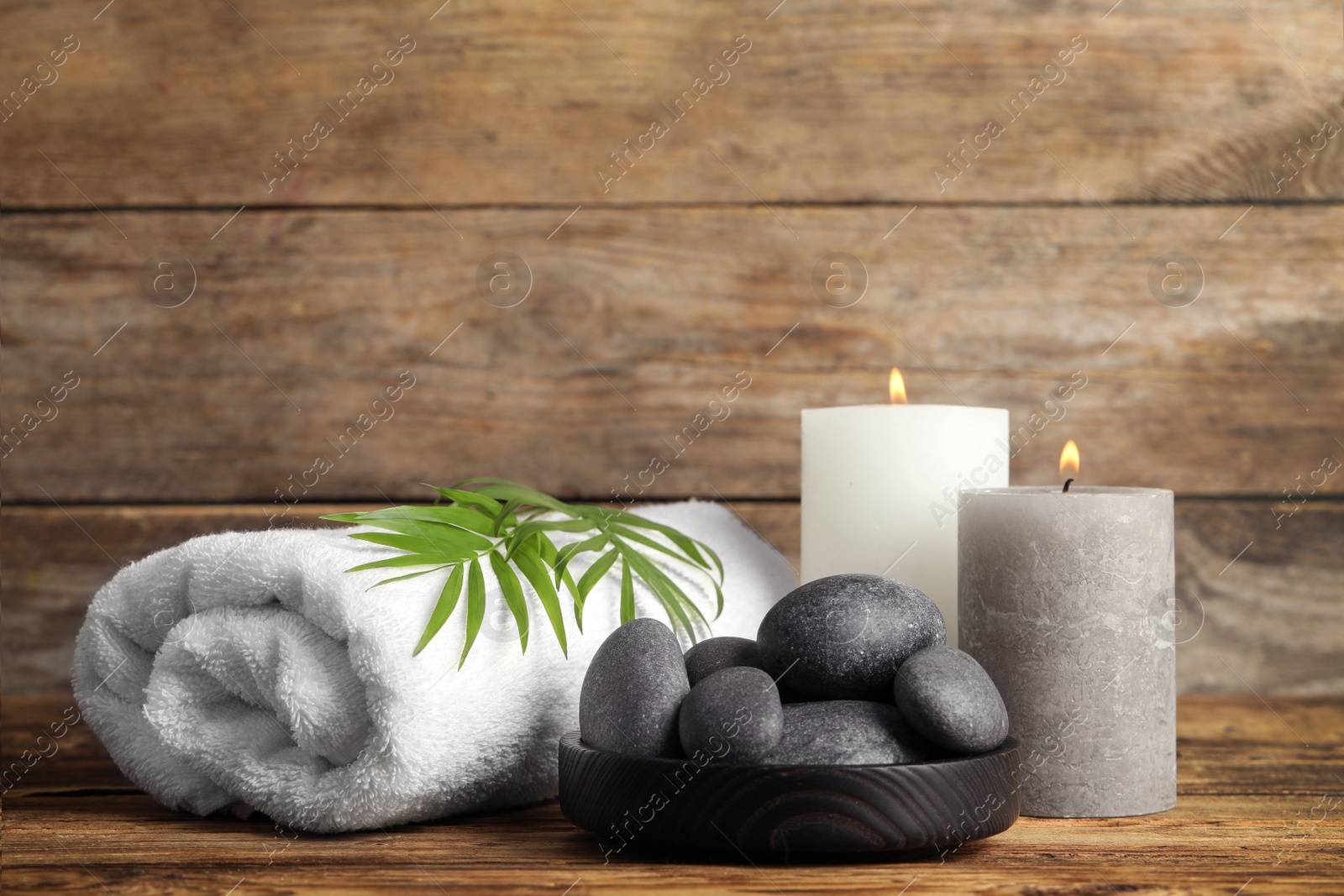 Photo of Composition with spa stones on wooden table