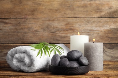 Photo of Composition with spa stones on wooden table