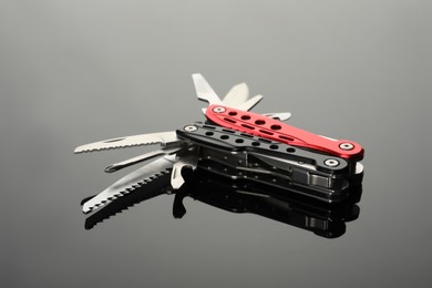 Photo of Modern compact portable multitool on grey table