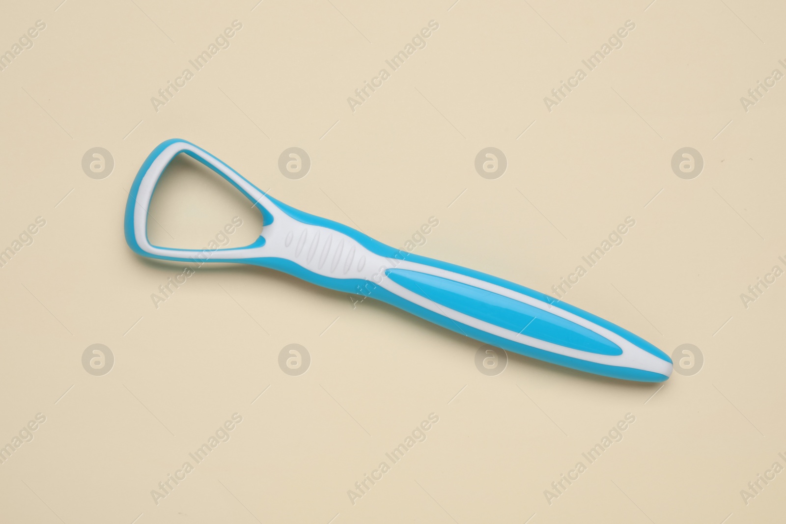 Photo of Light blue tongue cleaner on beige background, top view