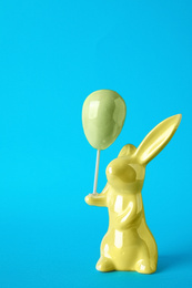 Photo of Bunny ceramic figure as Easter decor on blue background