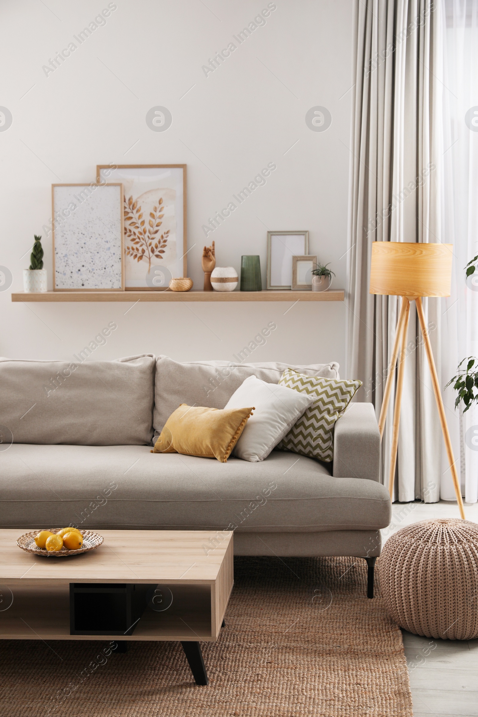 Photo of Stylish living room interior with comfortable grey sofa and coffee table