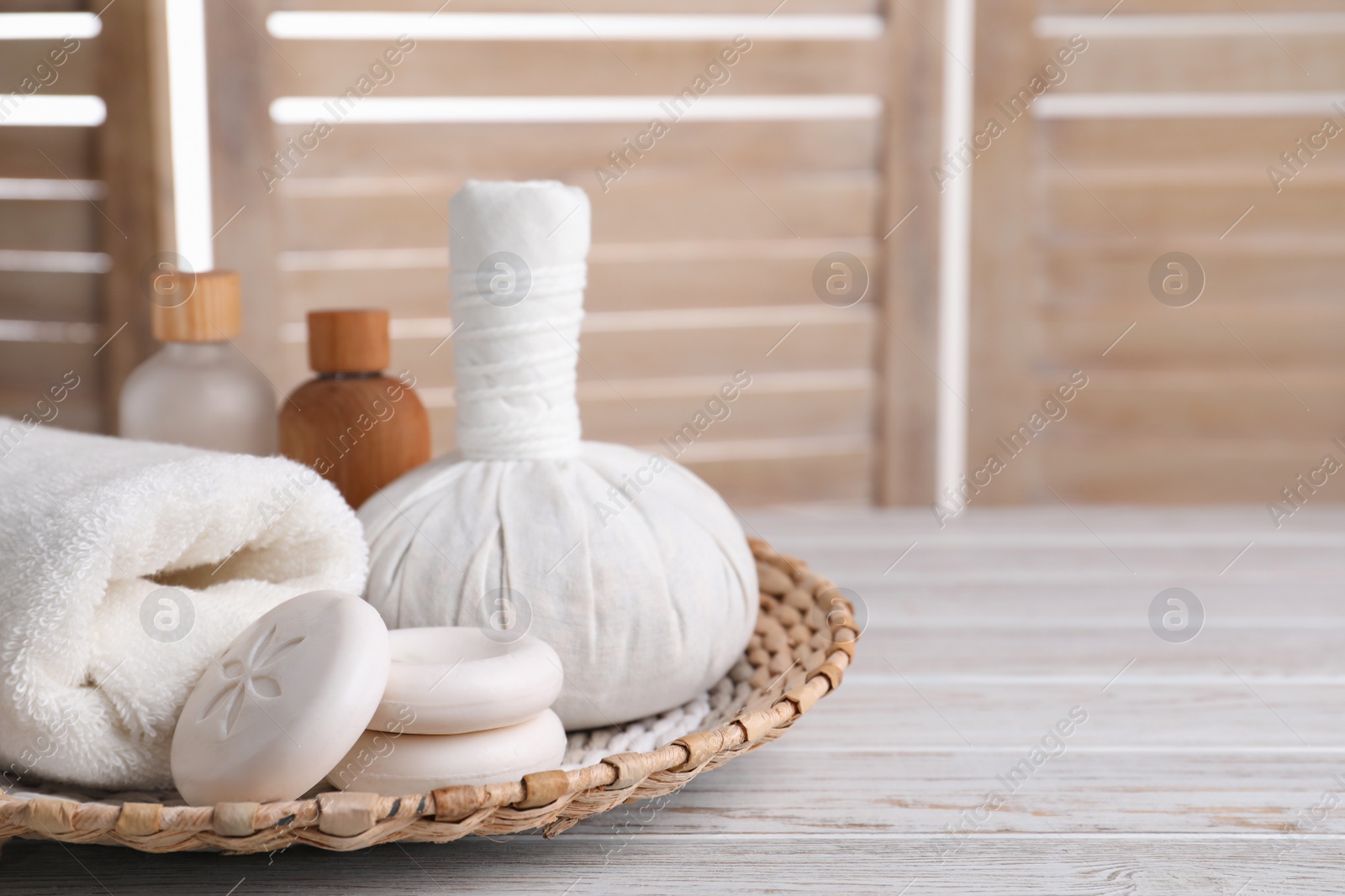 Photo of Spa composition with skin care products and wicker basket on white wooden table, space for text