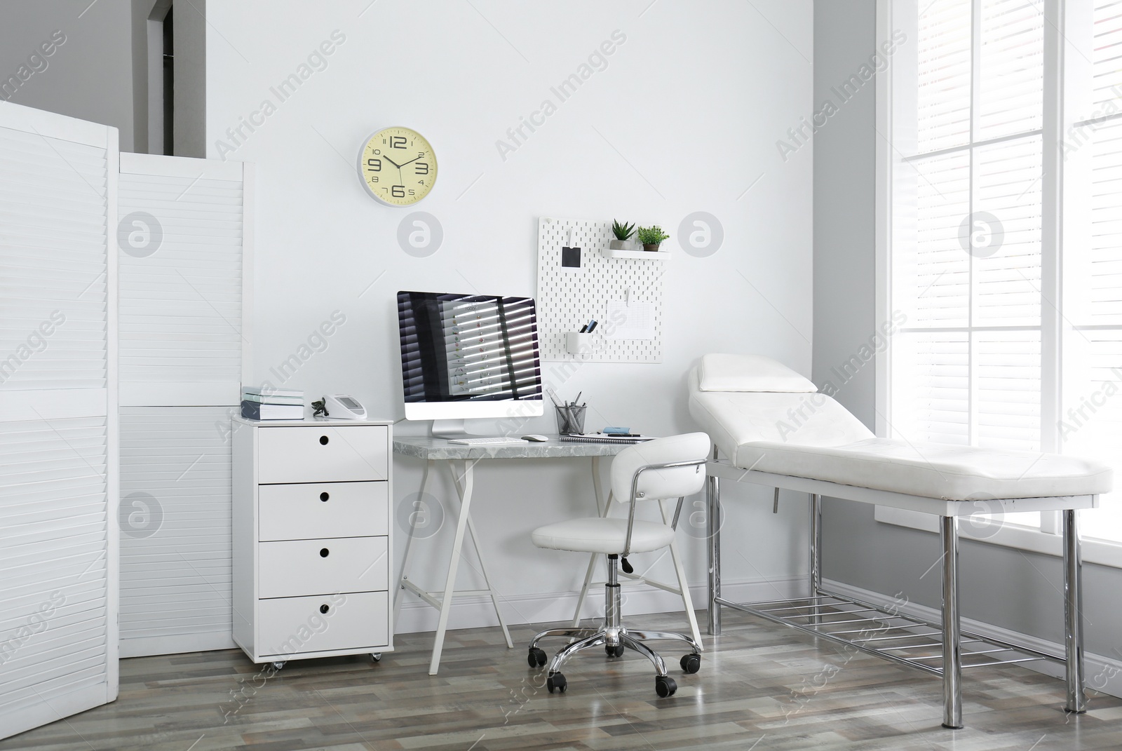 Photo of Modern medical office interior with computer and examination table