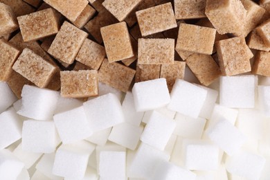 White and brown sugar cubes as background, top view