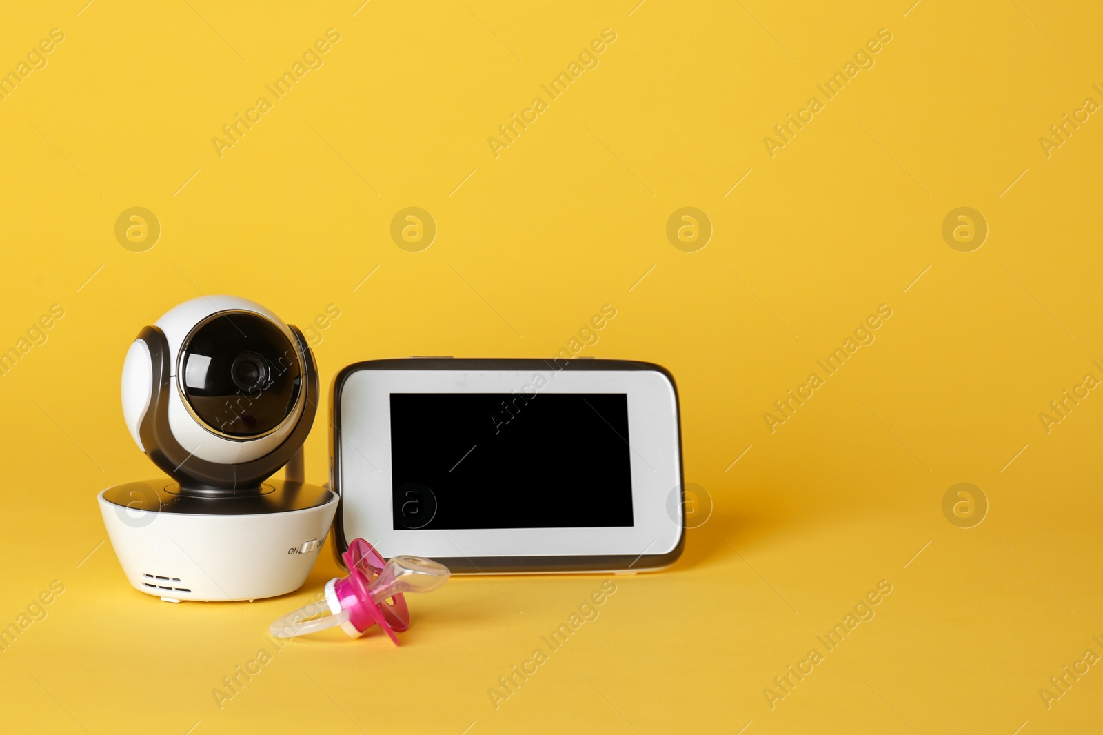 Photo of Modern CCTV security camera, pacifier and monitor on color background. Space for text