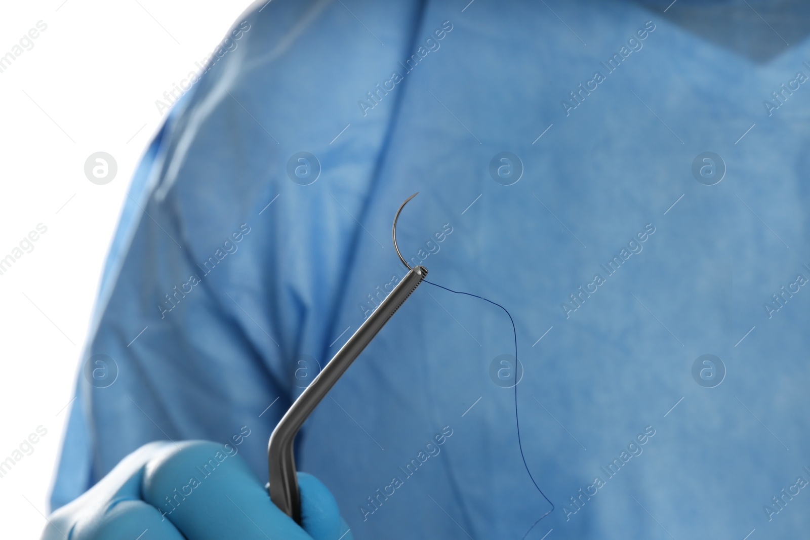 Photo of Doctor holding needle with suture thread on white background, closeup. Medical equipment