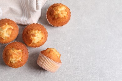 Tasty muffins on light grey table, flat lay. Space for text