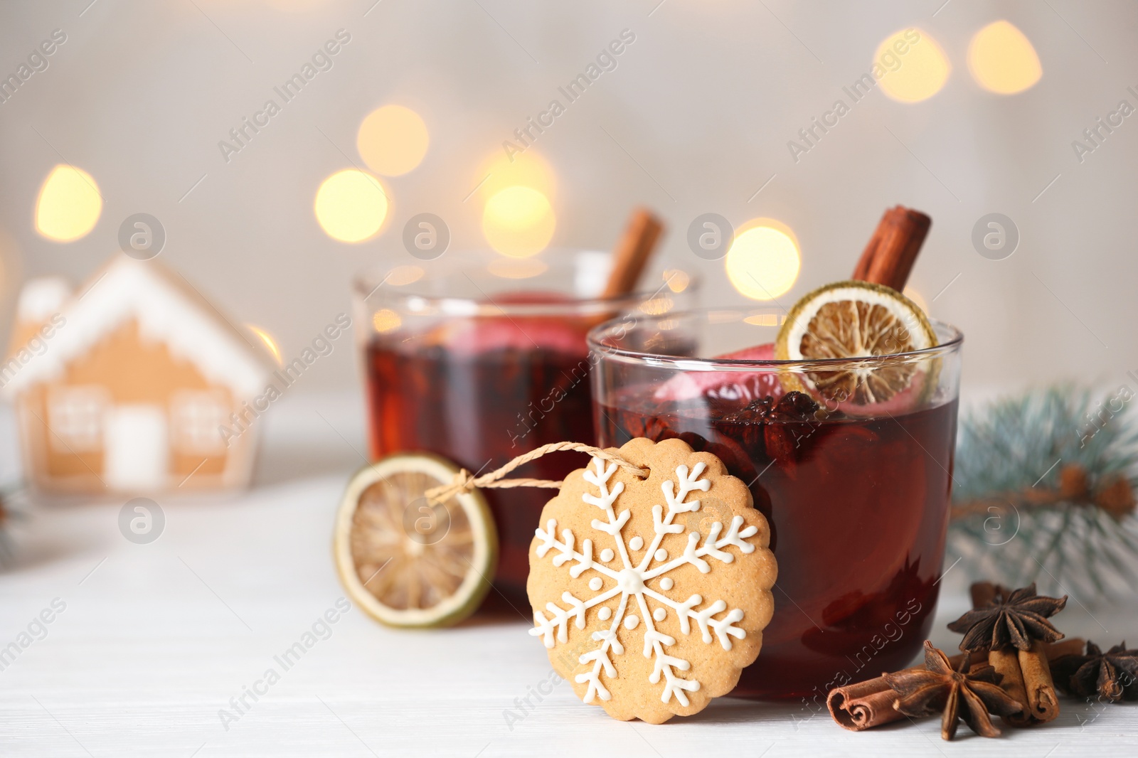 Photo of Mulled wine with cinnamon and cookie on table. Space for text