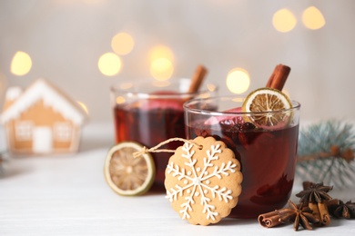 Photo of Mulled wine with cinnamon and cookie on table. Space for text