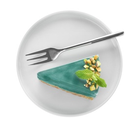 Plate with piece of delicious spirulina cheesecake isolated on white, top view