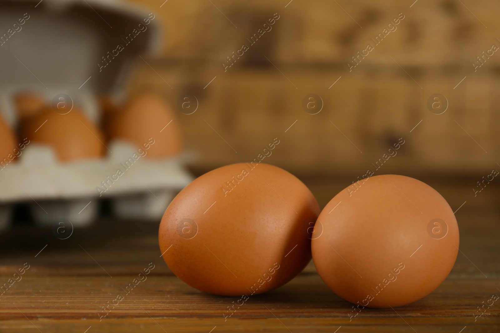 Photo of Raw brown chicken eggs on wooden table, closeup