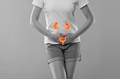 Woman suffering from cystitis on light grey background, closeup. Illustration of urinary system