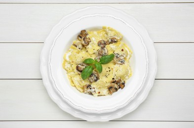 Photo of Delicious ravioli with mushrooms and cheese on white wooden table, top view
