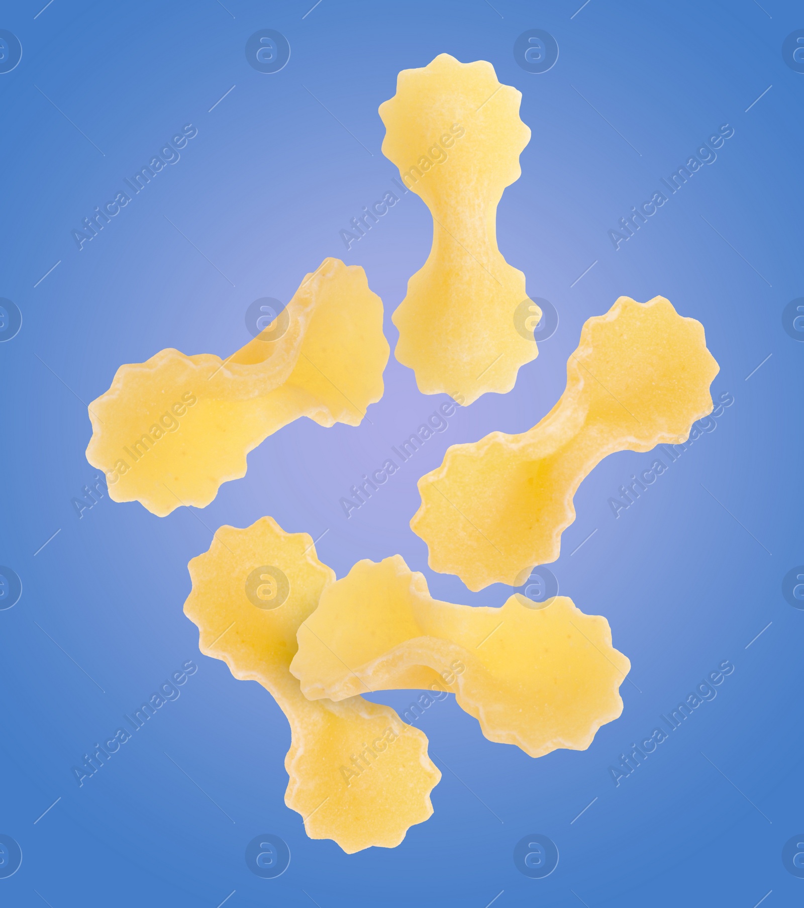 Image of Raw farfalline pasta falling on blue background