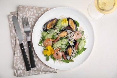 Plate of delicious salad with seafood on white table, flat lay