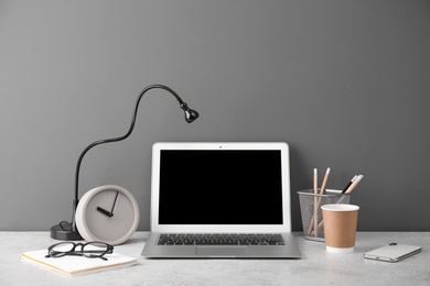 Photo of Modern workplace with laptop on table. Blank screen for mockup