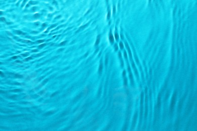 Image of Rippled surface of clear water on light blue background, top view