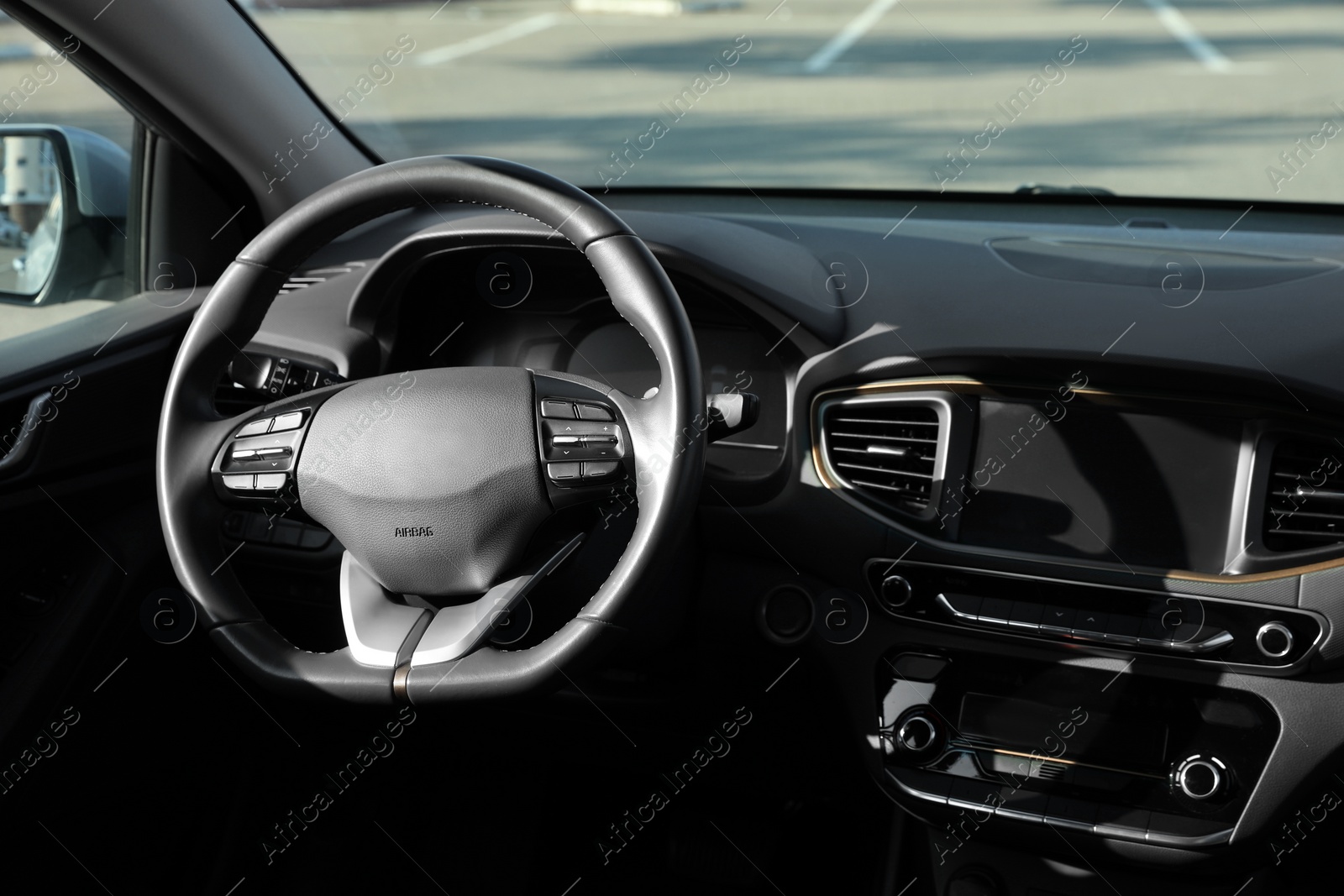 Photo of Black steering wheel and dashboard in modern car