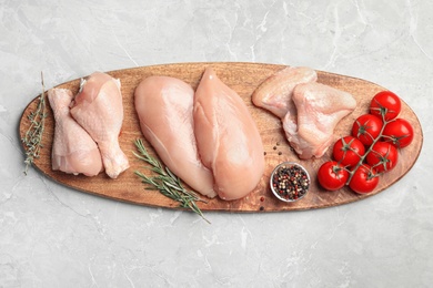 Flat lay composition with fresh chicken meat on light grey marble table