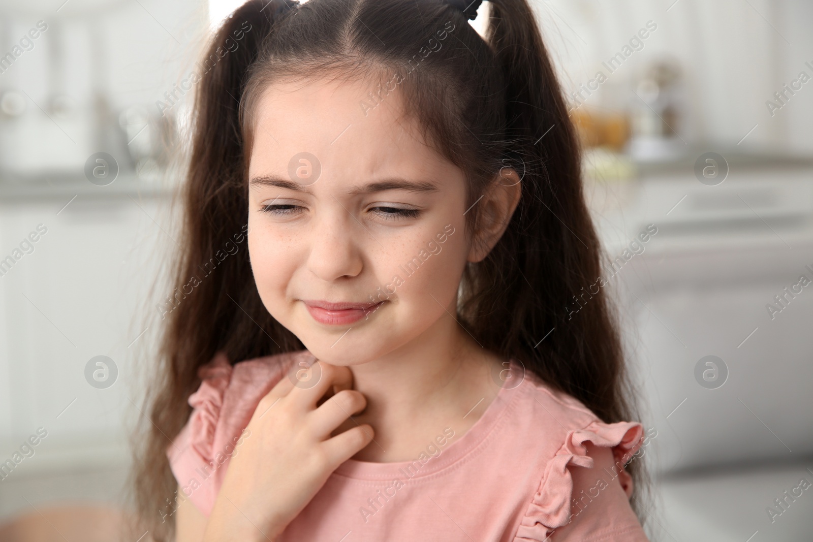 Photo of Little girl scratching neck at home. Annoying itch