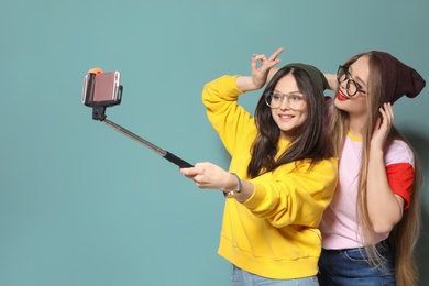 Attractive young women taking selfie on grey background