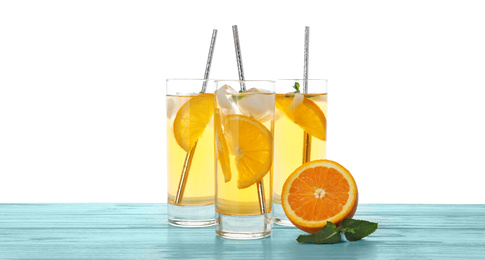 Delicious refreshing drink with orange slices on light blue wooden table against white background