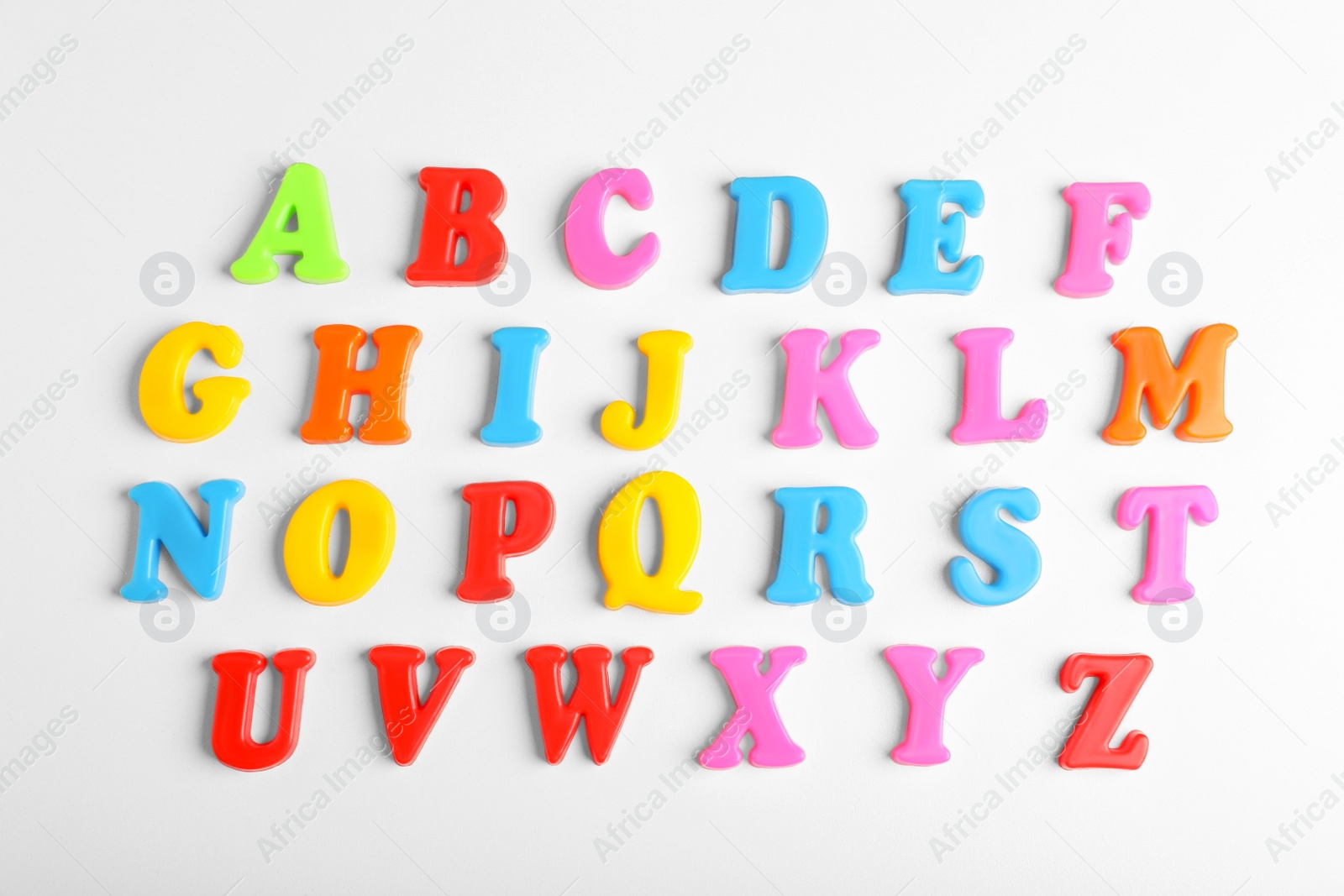 Photo of Colorful magnetic letters on white background, flat lay. Alphabetical order