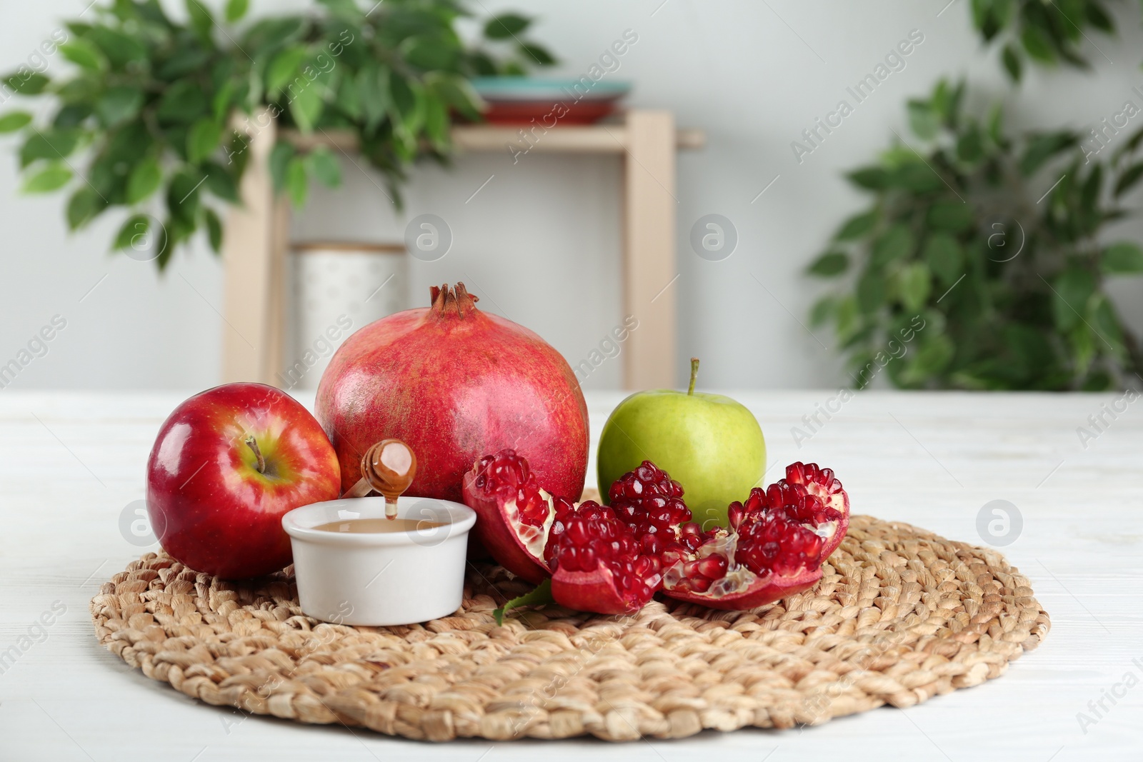 Photo of Honey, apples and pomegranate on white wooden table. Rosh Hashanah holiday