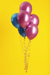 Bunch of bright balloons on color background