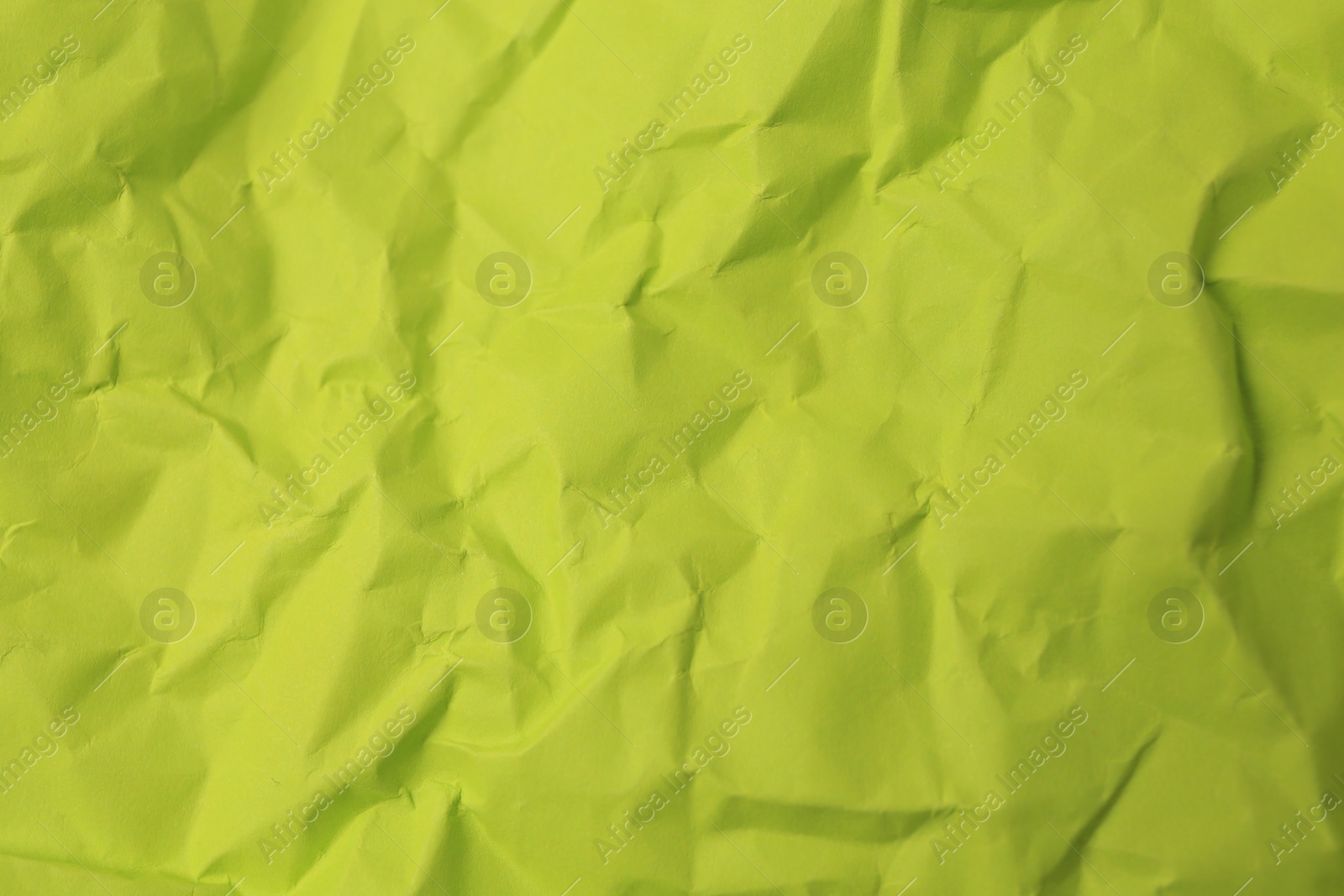 Photo of Sheet of crumpled light green paper as background, top view