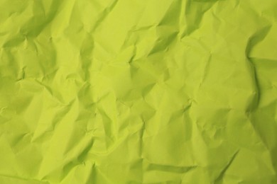 Sheet of crumpled light green paper as background, top view