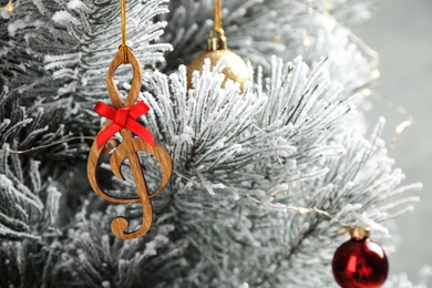 Photo of Fir tree with wooden treble clef and decor, closeup view. Christmas music