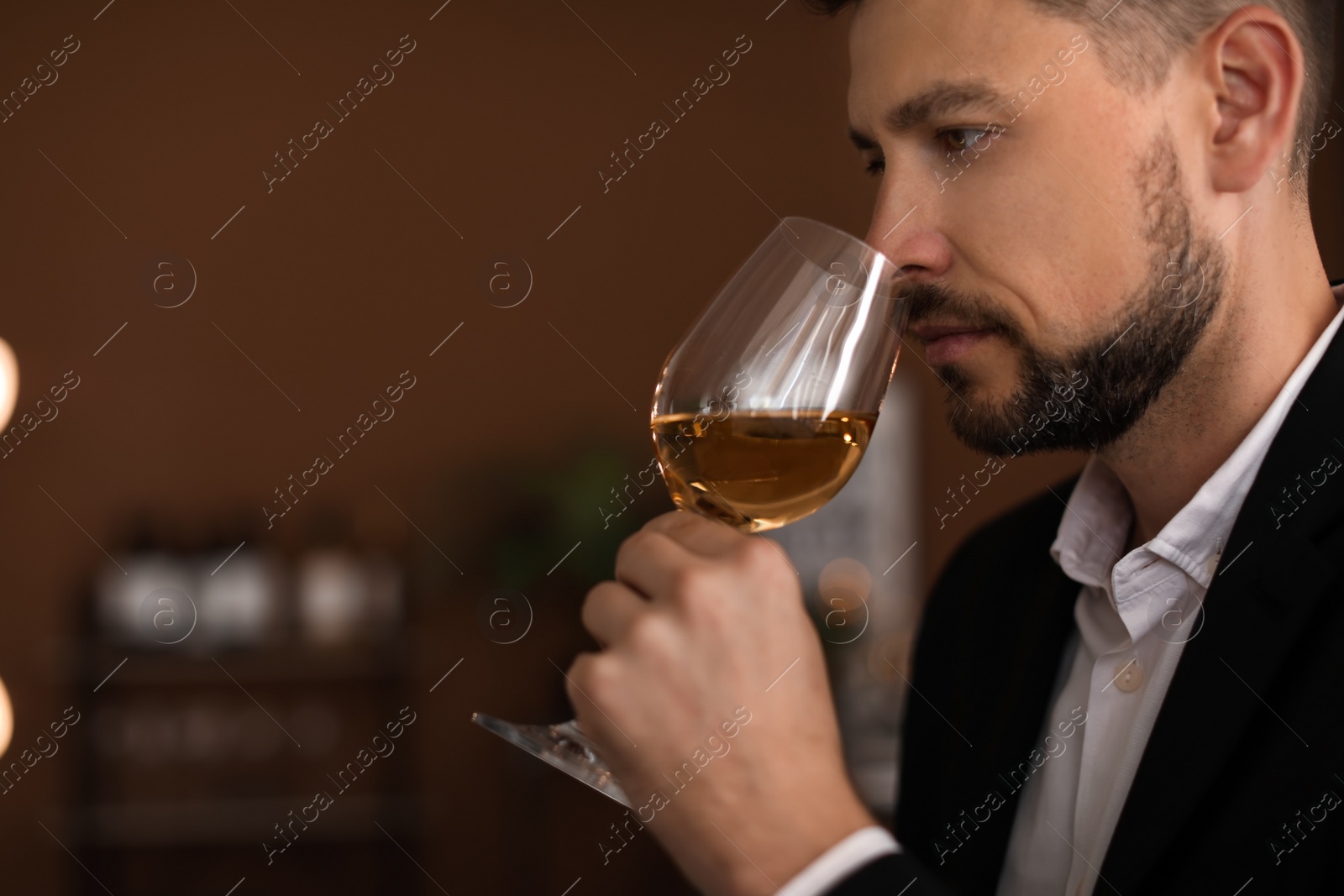 Photo of Young man with glass of wine indoors