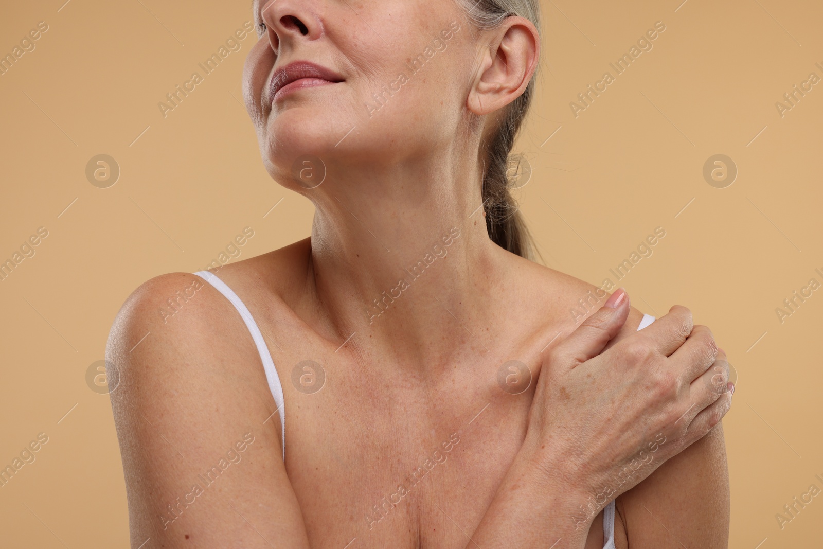 Photo of Mature woman with healthy skin on beige background, closeup