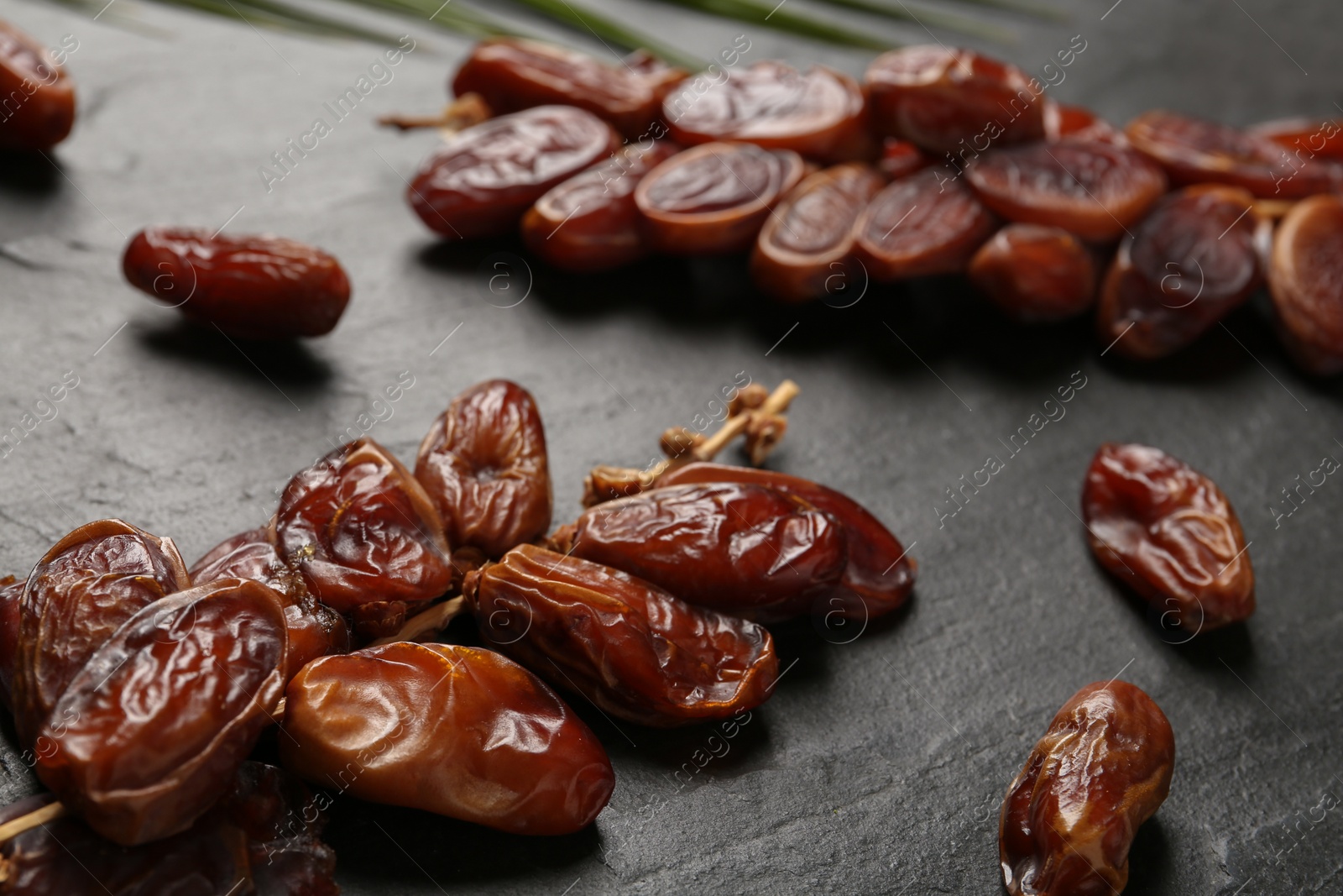 Photo of Tasty sweet dried dates on black table, closeup