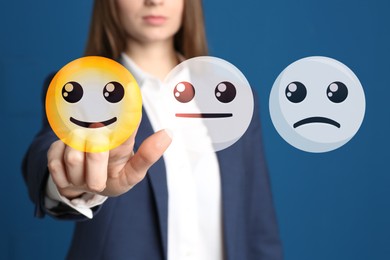Image of Woman pointing at virtual emoticon to give feedback on blue, closeup